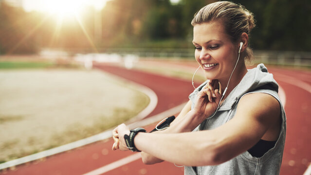 Young woman smiling while she feels her pulse before training