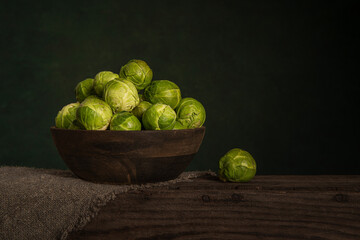Wooden bowl with a pile of brussels sprouts in a still life setting