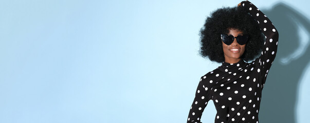 Happy black woman in a polka-dot blouse.