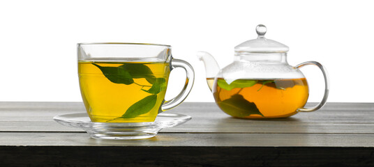 Refreshing green tea in cup and teapot on grey wooden table against white background