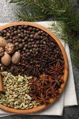 Different spices, nuts and fir branches on table, flat lay