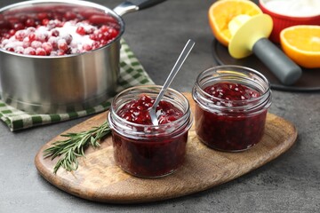 Fresh cranberry sauce in glass jars served on gray table