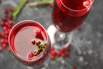 Tasty cranberry cocktail with rosemary in glasses on gray table, above view