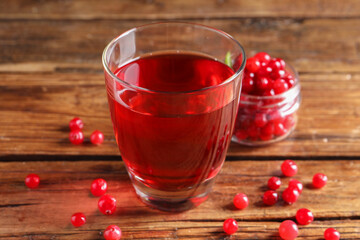 Tasty cranberry juice in glass and fresh berries on wooden table, closeup