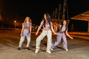 Young freestyle dancers performing in the street at night