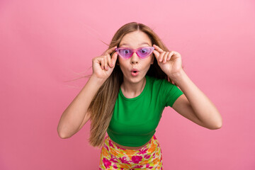 Photo of impressed astonished girl wear green trendy clothes hold glasses look camera isolated on pink color background