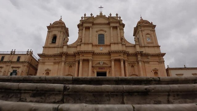 Walking up stairs reveals beautiful Noto Cathedral, an important landmark in Eastern Sicily Italy
