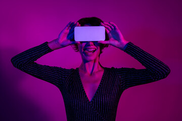 Photo portrait of lovely young lady cover eyes white screen dressed stylish overall garment isolated on neon light pink color background