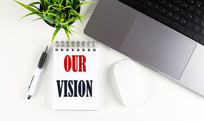 OUR VISION text written on notebook with laptop and mouse , white background