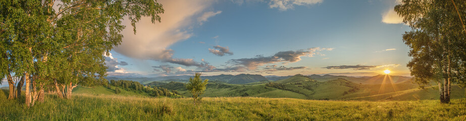 Evening rural landscape, the setting sun, sunset, spring nature, meadows and hills	