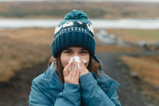Cold weather woes: woman blows nose in Iceland