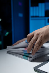 An employee held a large pile of documents in his hand, Large piles of work documents on desks are...