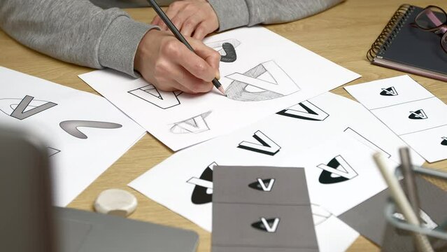 Logo design and creation. The designer draws a sketch of the brand on paper.