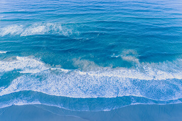 Ocean surf. Waves roll onto the shore. View from above. Natural abstract background