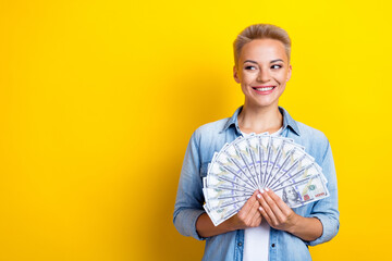 Photo portrait of lovely young lady hold dollars fan look empty space dressed stylish denim garment...