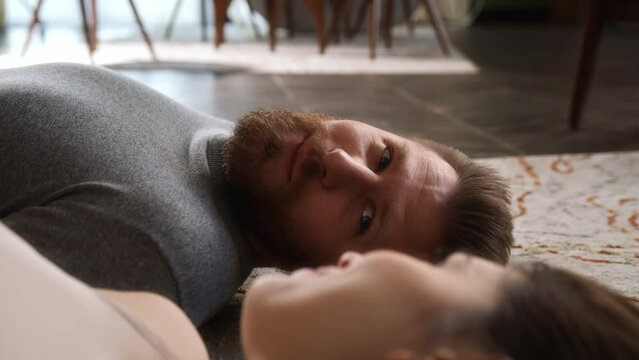 close up view of young man face, laying on floor with his girlfriend and looking in her eyes with love. gentle glance on lover woman.