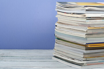 Open stacking book, hardback colorful books, magazine on wooden table and purple background. Back to school. Copy space for text. Education business concept.