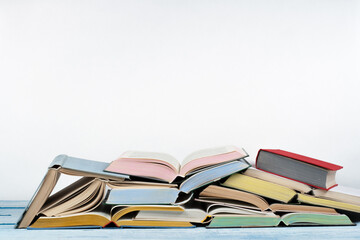 Open book, hardback colorful books on wooden table , white Background. Back to school. Copy space for text. Education business concept.