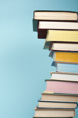 Open stacking book, hardback colorful books on wooden table and blue background. Back to school. Copy space for text. Education business concept.