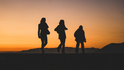 Obraz premium silhouettes of people on the beach at sunset