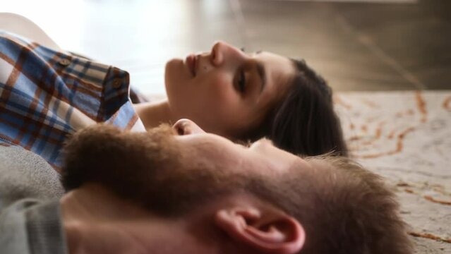 close up view of young woman face, laying on floor with her boyfriend and looking in his eyes with love. gentle glance on lover man.