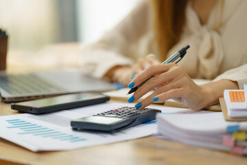 Close-up portrait of businesswoman accountant using calculator and laptop for matching financial...