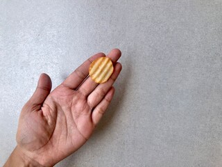 Hand holding Crispy corrugated potato chips or potato chips background. Junk food. Close up