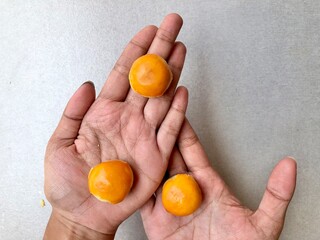 Hand holding Pineapple Cookies called Kue Nenas or Nastar in Indonesian, is one of the most popular traditional sweets to celebrate Eid al-Fitri. Selective focus.