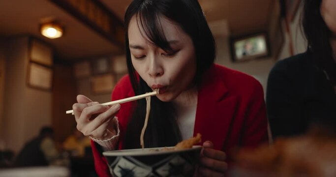 Woman, noodles and eating food in restaurant for nutrition, healthy meal and closeup with chopsticks. Person, Japanese cuisine and ramen for lunch or dinner in cafeteria with vegetable and hungry