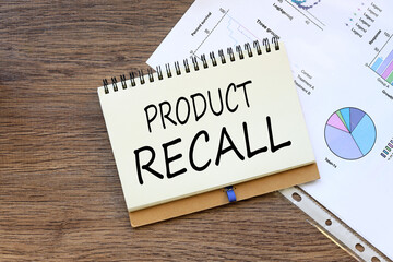 Product Recall office desk, financial charts. words on the page