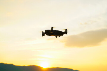 Fototapeta na wymiar Silhouette drone flying over lake sunset