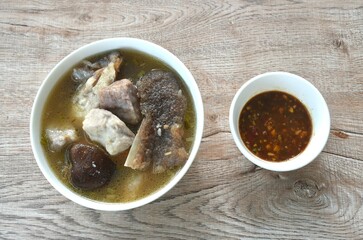 boiled fried grouper fish head and slice taro with black mushroom in soup on bowl dipping spicy chili soy sauce