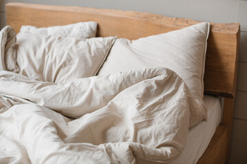 A bed with crumpled, stylish bed linen.