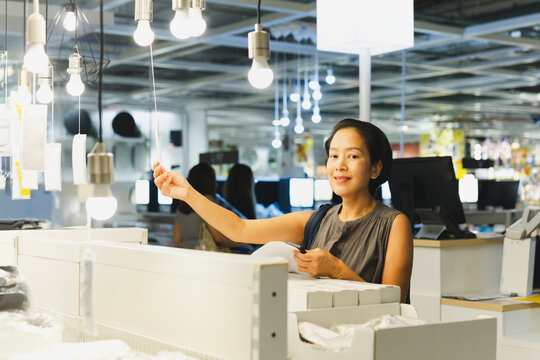 Energy efficient lighting choice: Woman holding and choosing a LED light bulb.