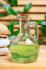 Glass bottle with liquid soap and other spa cosmetics on the table.