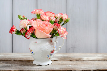 Beautiful bouquet of carnation and rose flowers in a vase.