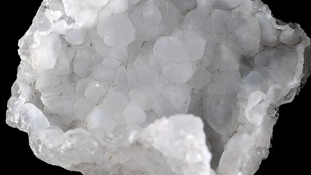 Snow Chalcedony (quartz) specimen rotating slowly against a black background.	