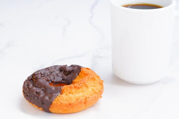 チョコレートでコーティングされたオールドファッションドーナツとコーヒーでコーヒーブレイクの時間
