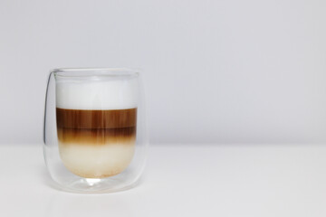 glass of fresh latte coffee with milk on white table and copy space
