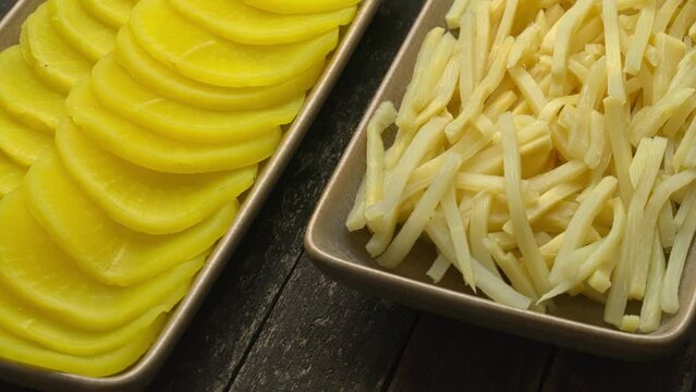 Asian style pickle: turmeric pickled daikon (takuan) and bamboo shoots. Table spin.