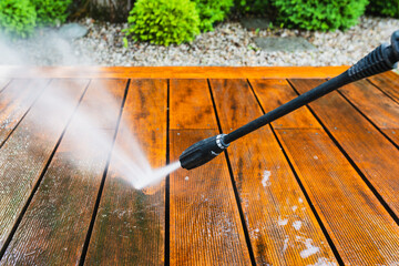 cleaning terrace with a power washer - high water pressure cleaner on wooden terrace surface. - 740771313