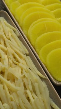 Asian style pickle: turmeric pickled daikon (takuan) and bamboo shoots. Table spin. Vertical video.