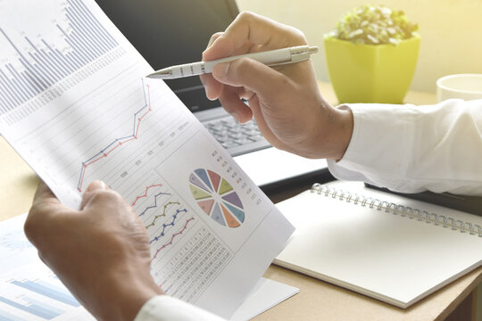 businessman analysis financial graphs and charts report on desk in office. business strategy concept.