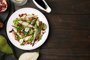 Delicious pear salad with sauce on wooden table, flat lay. Space for text