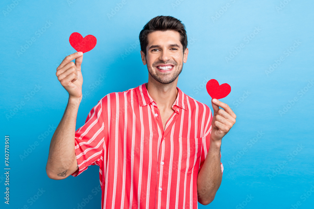 Sticker photo of romantic positive man with bristle dressed striped shirt hold two paper heart postcards iso