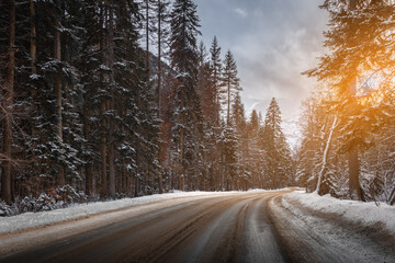 empty road through the winter mountain forest at sunset - 740780731