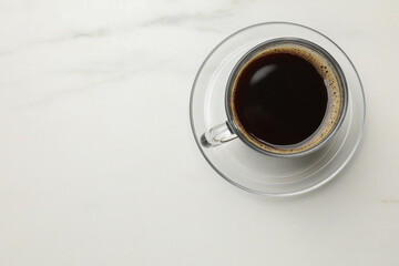 Cup of aromatic coffee on white table, top view. Space for text