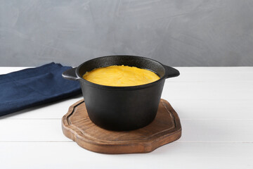 Fondue with tasty melted cheese on white wooden table