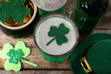 St. Patrick's day party. Green beer, leprechaun hat, pot of gold and decorative clover leaves on...