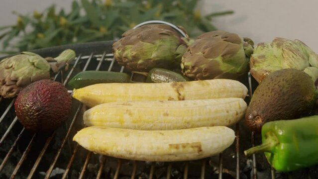 Grilled Banana on fire, latin american vegan grill with avocado and pepper, thai or Ecuadorian Street food. African traditional food on grill. 